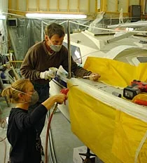 Sanding a fiberglass hull in the shop